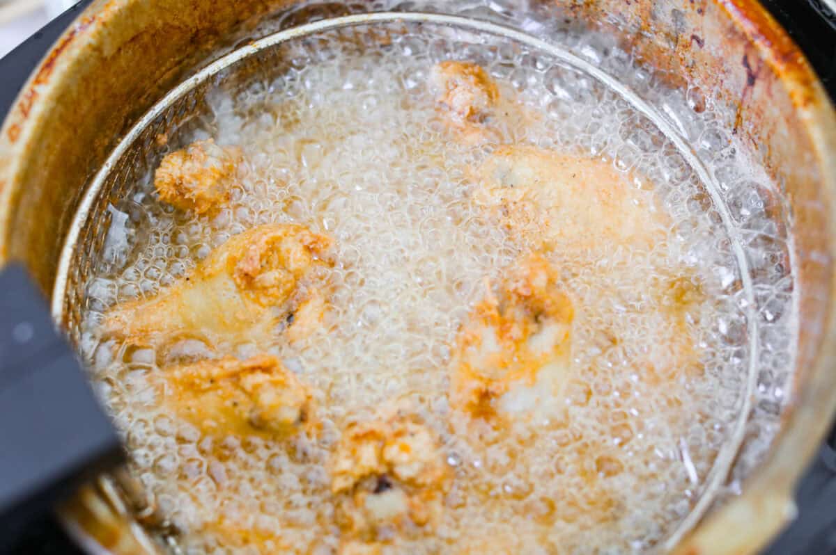 Chicken wings being deep fried in oil. 