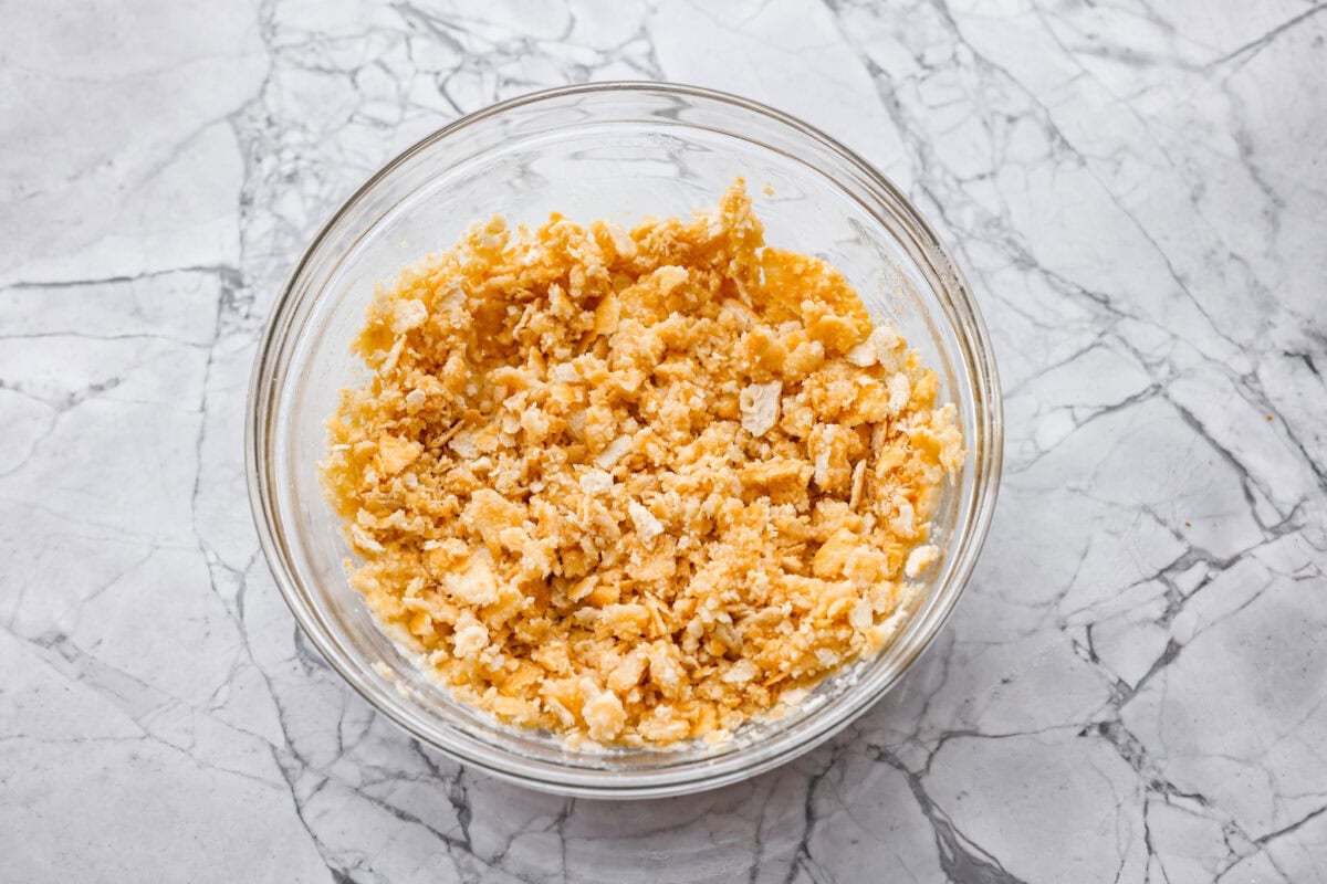 Crushed ritz crackers mixed with melted butter in a bowl. 