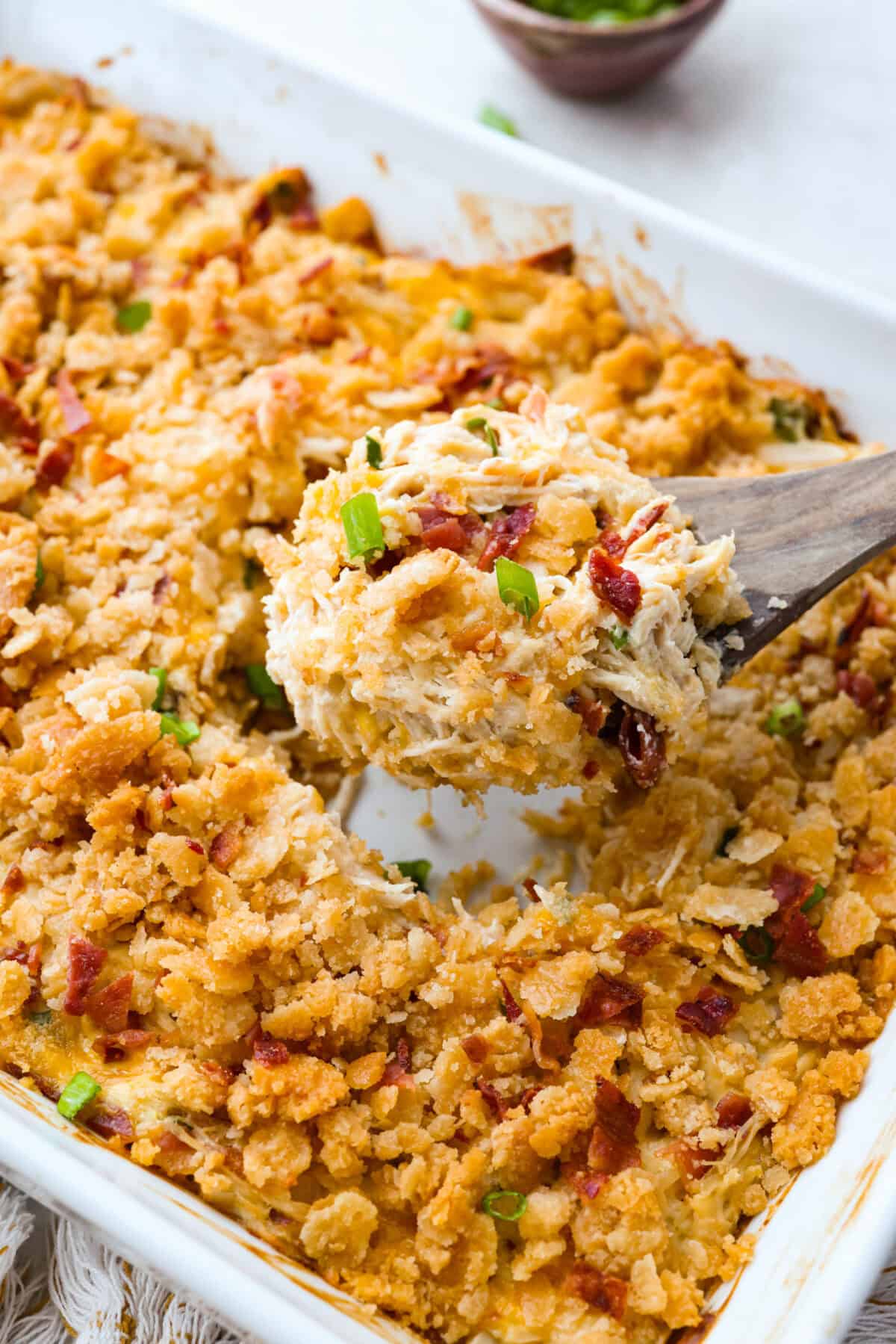 Someone taking a scoop out of the Neiman Marcus chicken casserole dish. 