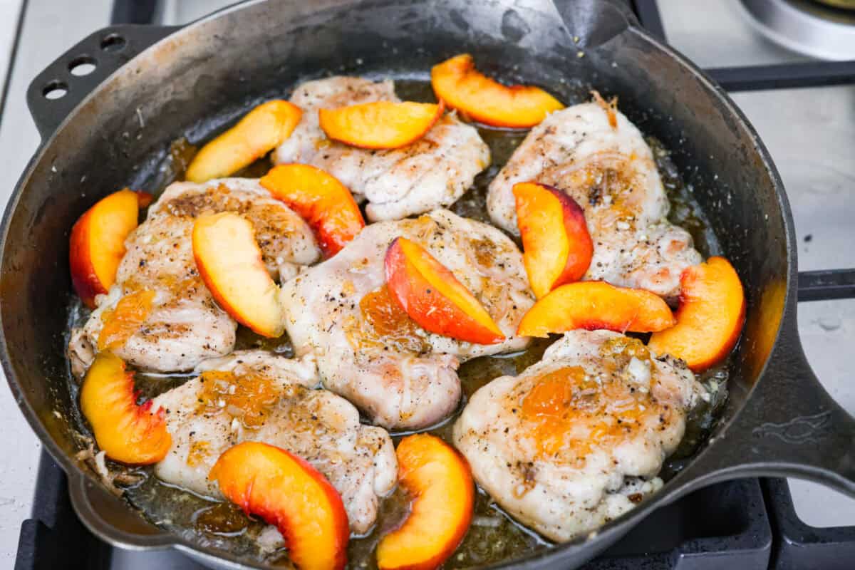 Chicken added back to the skillet with sliced peaches on top. 