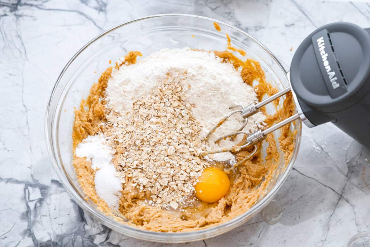If you grew up in Utah, Lunch Lady Peanut Butter Bars were basically a rite of passage. Thick, chewy, and slathered in chocolate frosting. My version is even better, and yes, this one earned its spot in my cookbook for a reason. Eggs, salt, baking soda, rolled oats, and flour added to the sugar and butter mixture.