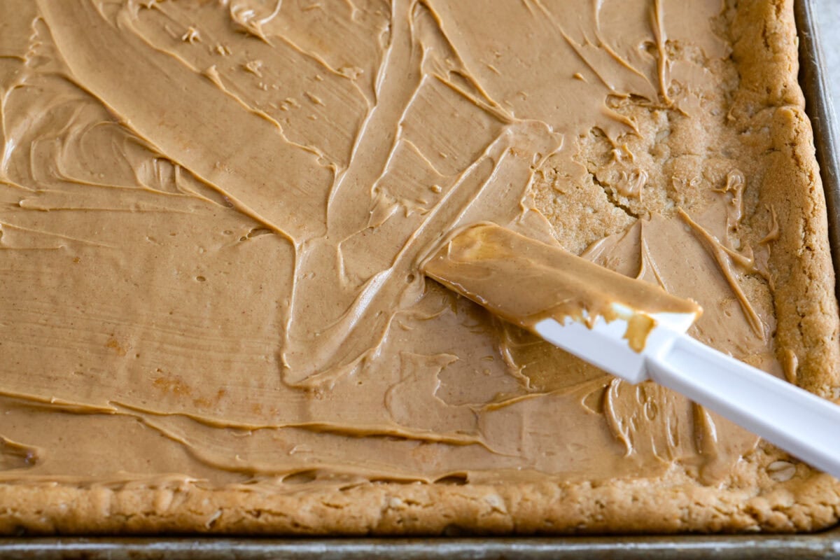 If you grew up in Utah, Lunch Lady Peanut Butter Bars were basically a rite of passage. Thick, chewy, and slathered in chocolate frosting. My version is even better, and yes, this one earned its spot in my cookbook for a reason. Peanut butter spread and layered onto the cookie bar.