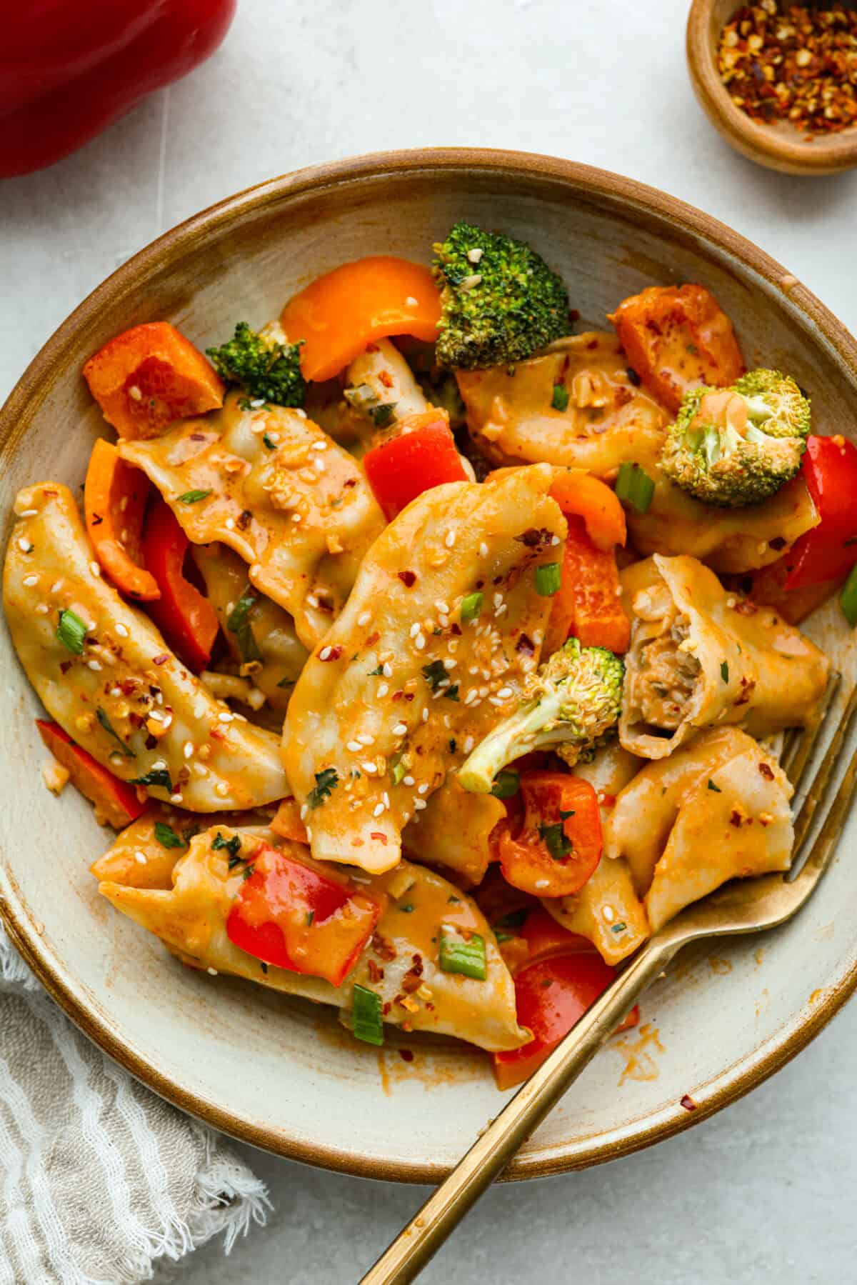 Bowl of potsticker casserole with a gold fork.