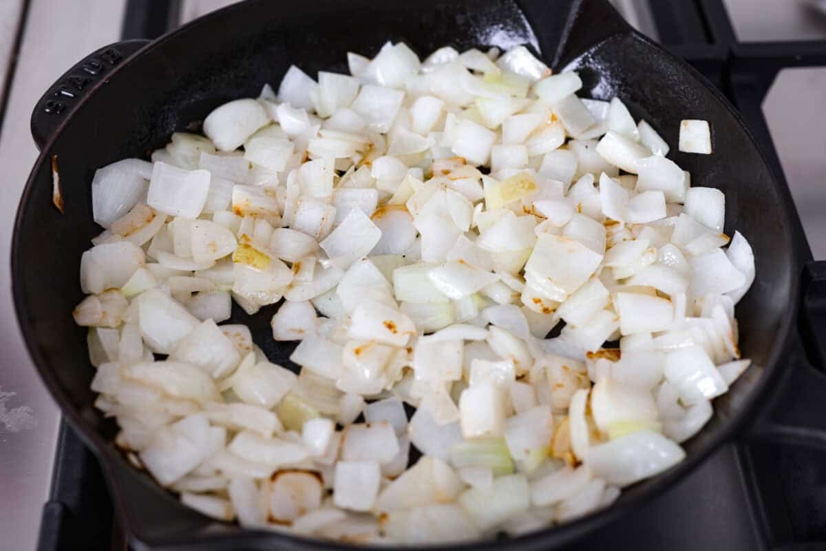 Skillet full of chopped onions cooking. 