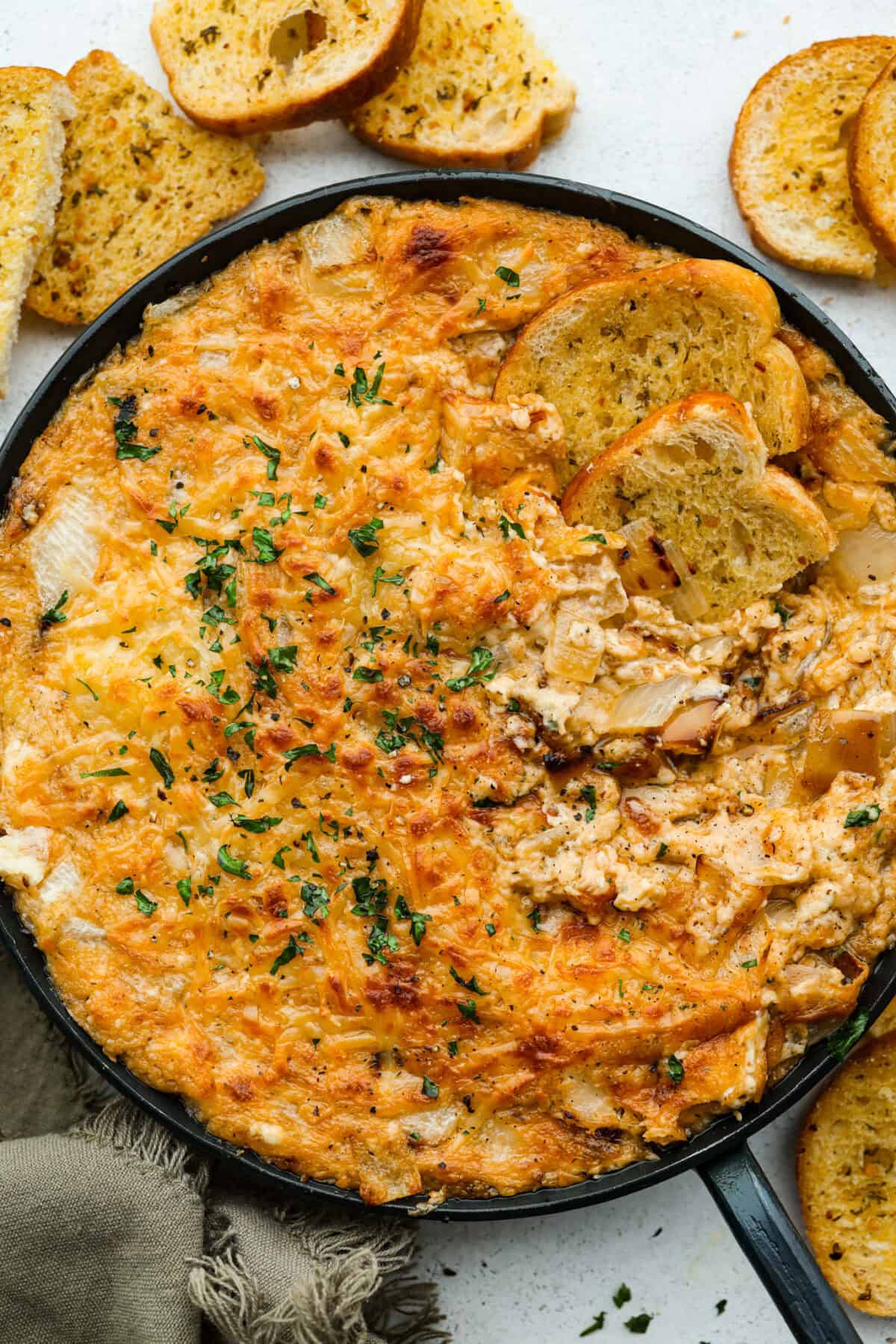 Skillet full of Tennessee onion dip, with a few slices of crostini. 