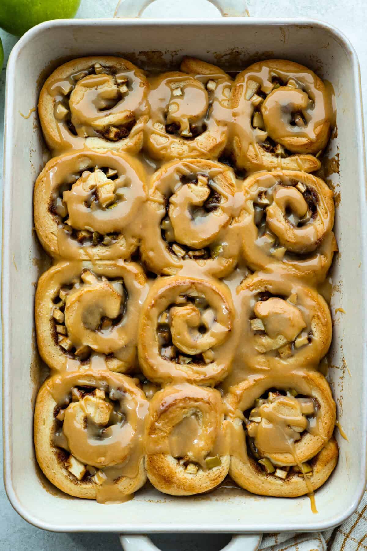 Overhead shot of baked and glazed caramel apple cinnamon rolls.