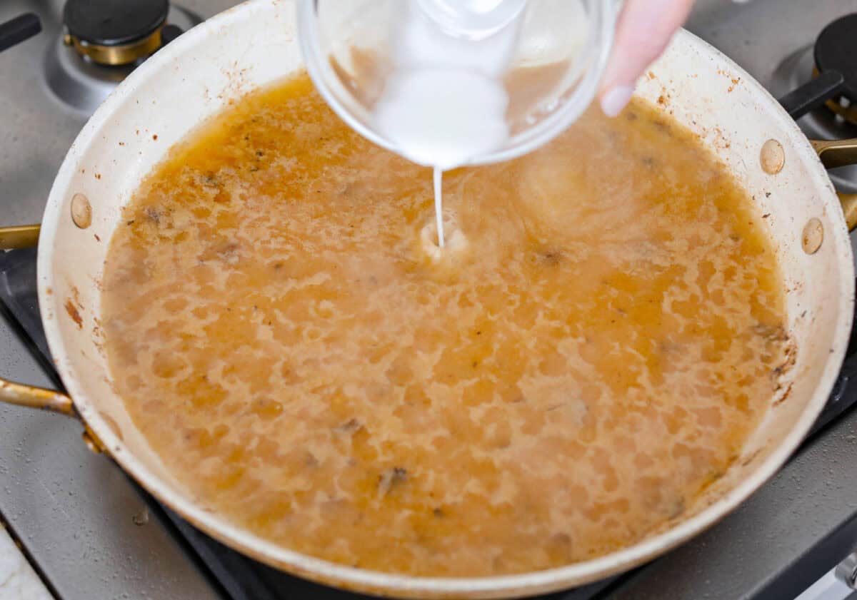 Someone thickening the sauce with the cornstarch mixture. 