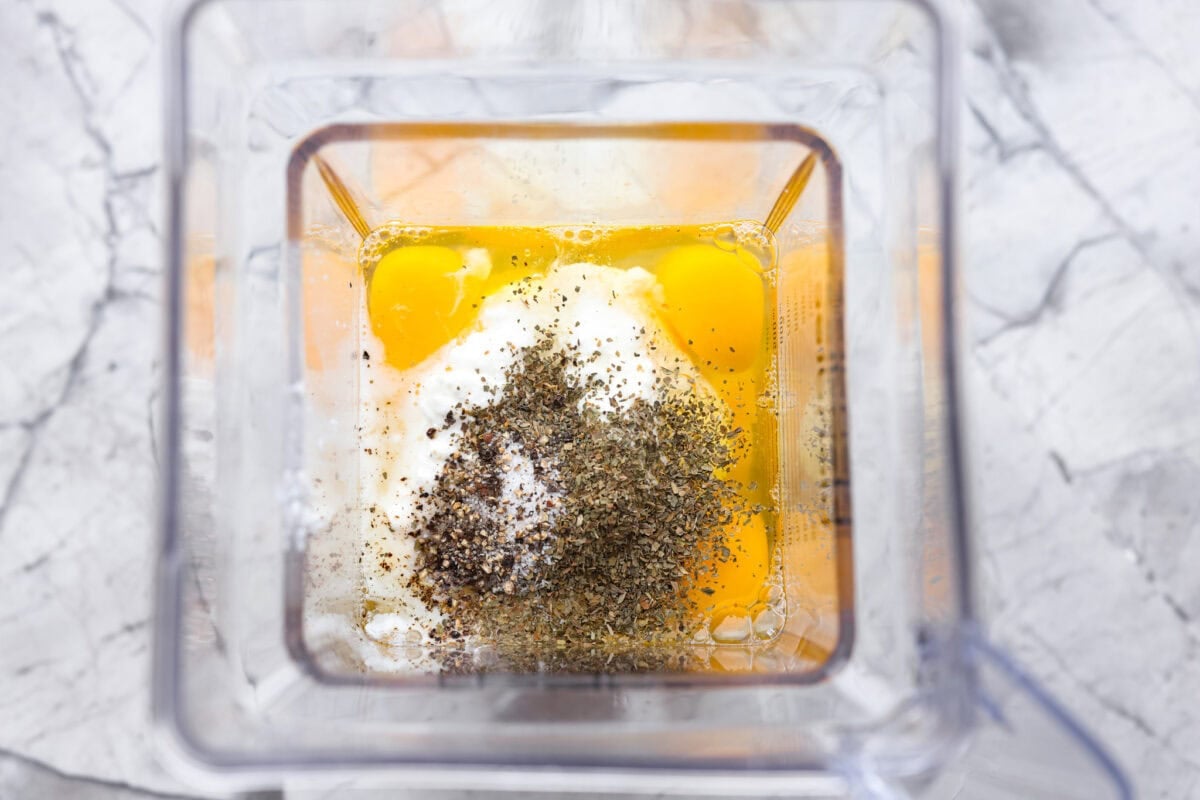 Eggs, cottage cheese, and seasonings inside a blender. 