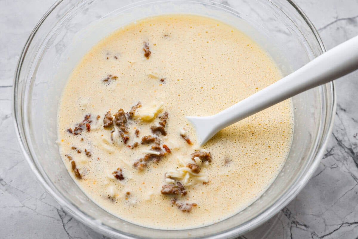 Cooked sausage, sun-dried tomatoes, and shredded cheese added to the egg mixture. 