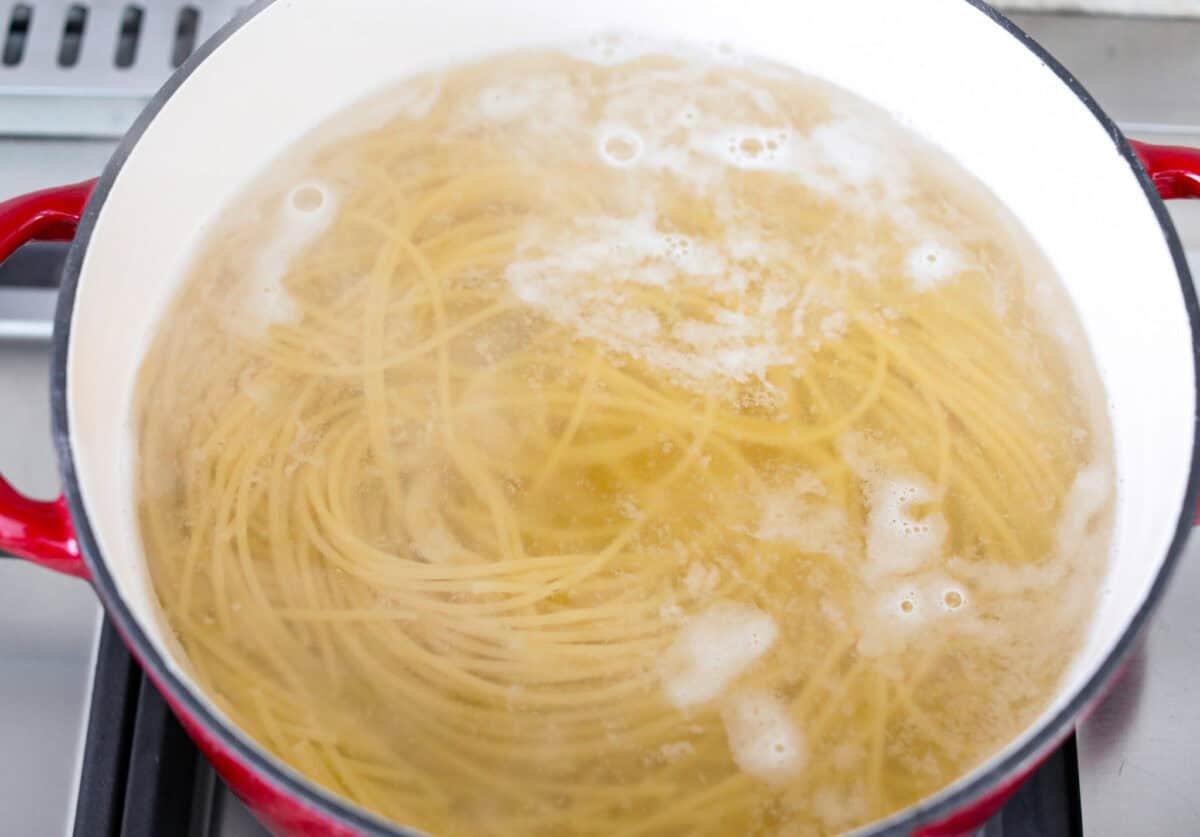 Pot of noodles cooking in boiling water.