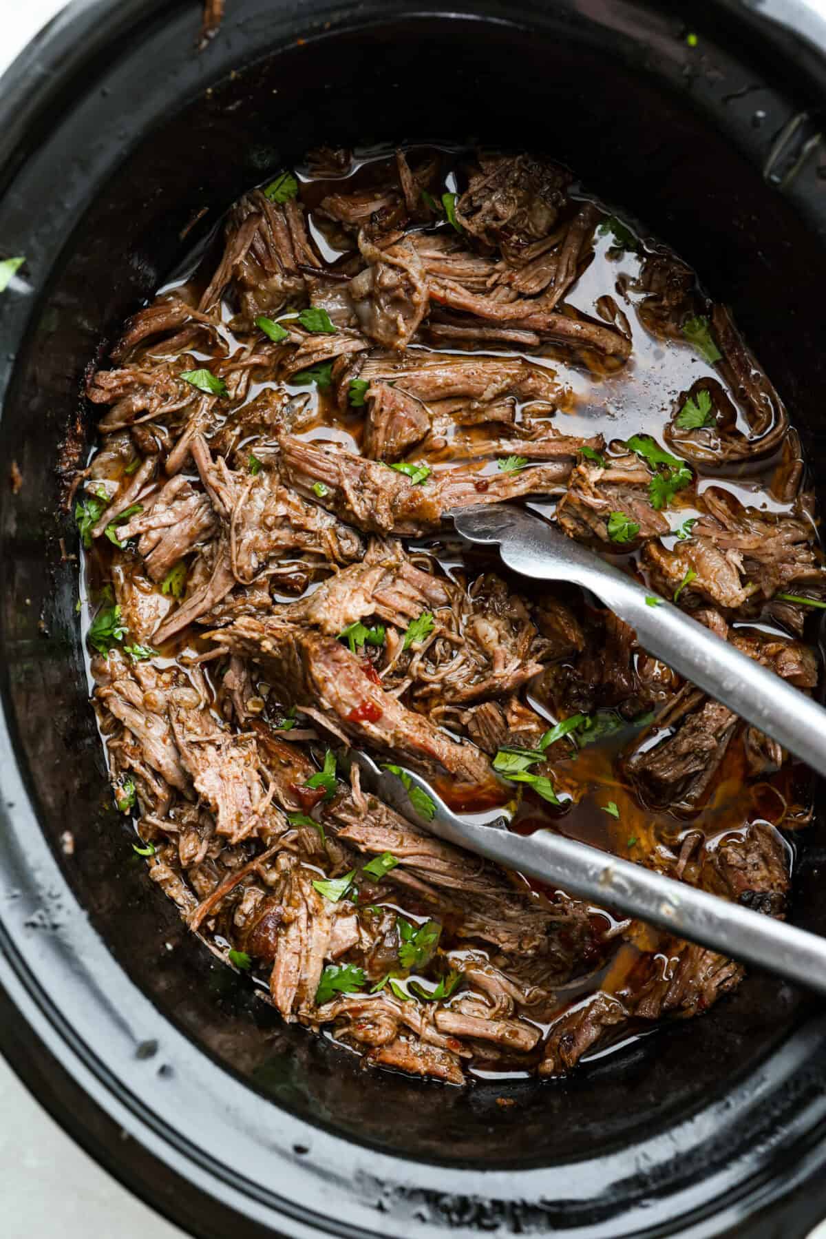 Overhead shot of slow cooker Barbacoa beef still in the crockpot. 