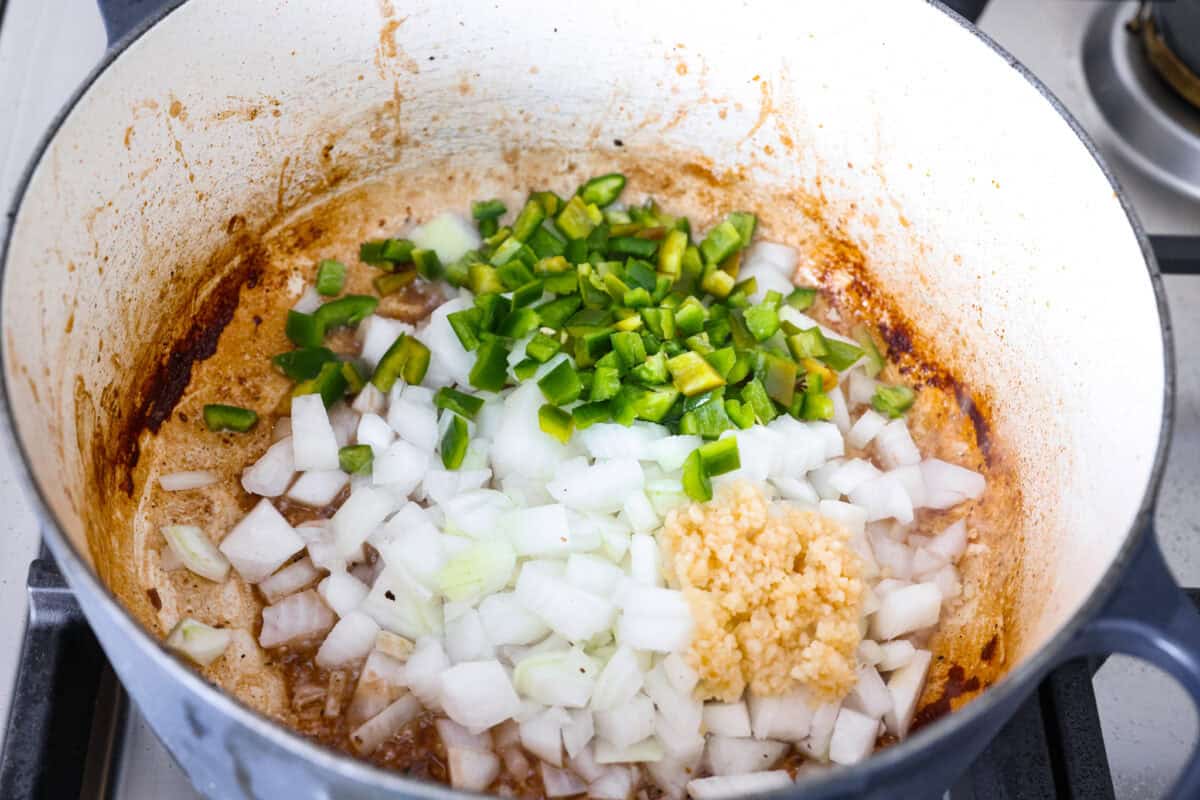 Do you like your chili with beans or without? This authentic Texas chili keeps it classic. Just bold, tender chuck roast, without beans. It has a rich, smoky flavor in every bite. Jalapenos, onion and garlic cooking in the bottom of the dutch oven with the leftovers from the beef.