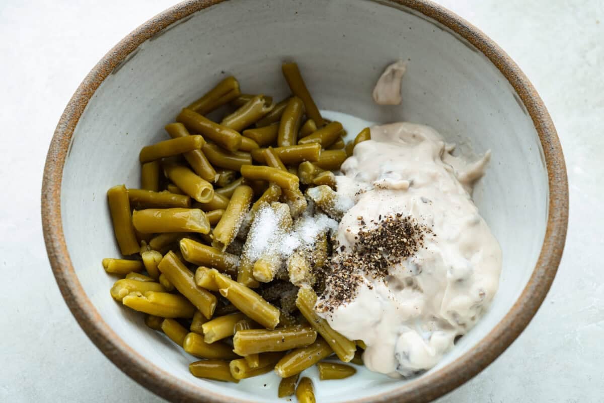 Beans, soup, salt, and pepper added to a mixing bowl.