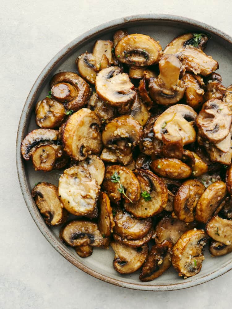 Top-down view of garlic parmesan air fryer mushrooms on a gray plate.