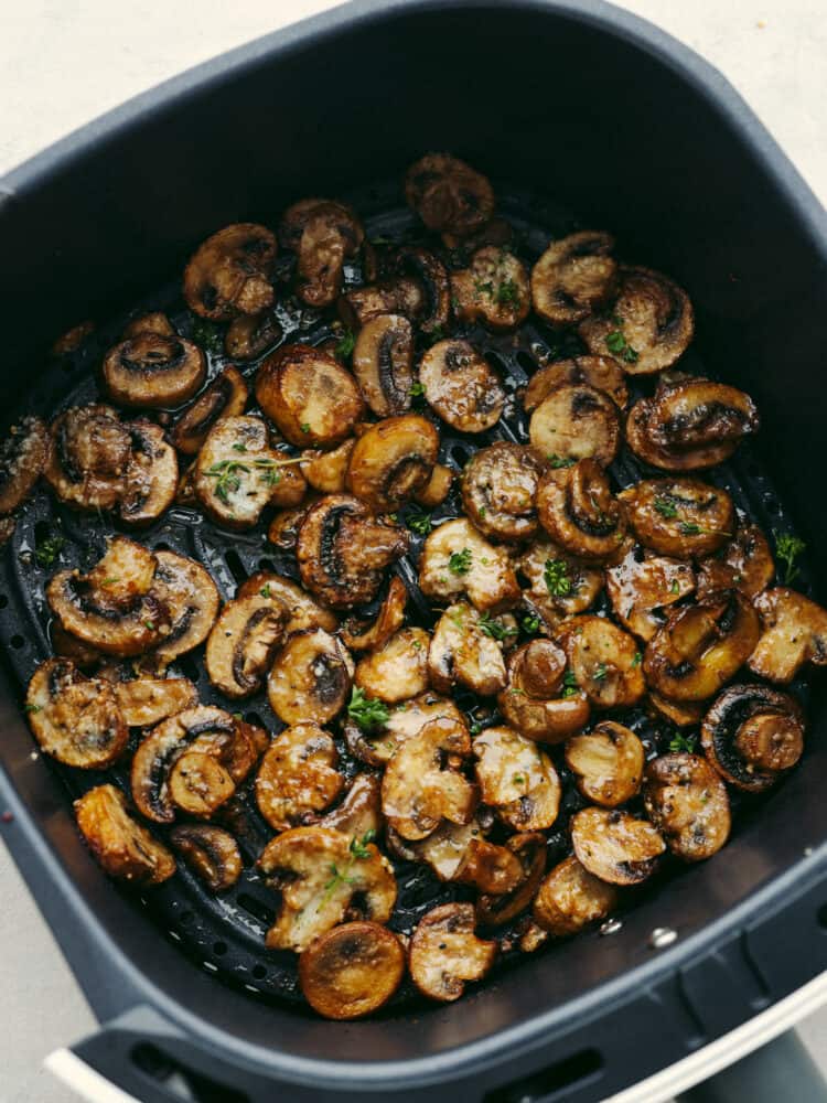 Air fryer mushrooms cooked in the bottom of the basket.