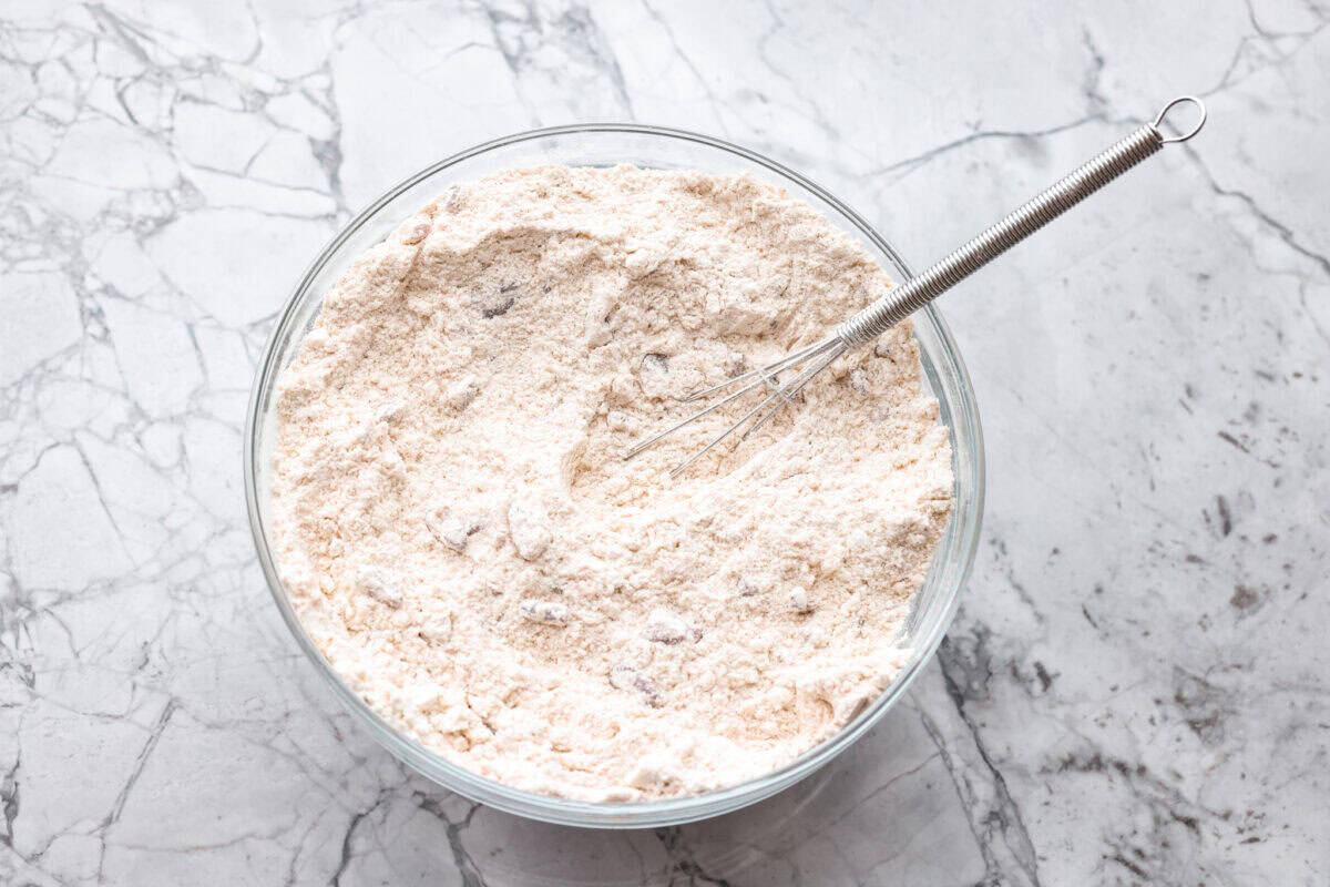 Cake mix, pecans, and cinnamon whisked together in a bowl.