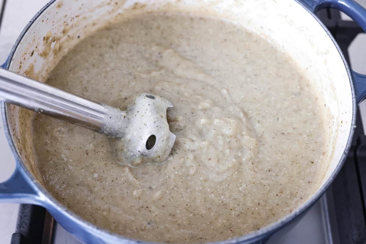 Creamy roasted garlic soup is comfort food with a side of obsession. Combining roasted garlic, tender potatoes, and nutty Parmesan into a cozy soup is absolute perfection. Just make sure you serve it to anyone within hugging distance. Soup mixed together with an immersion blender.