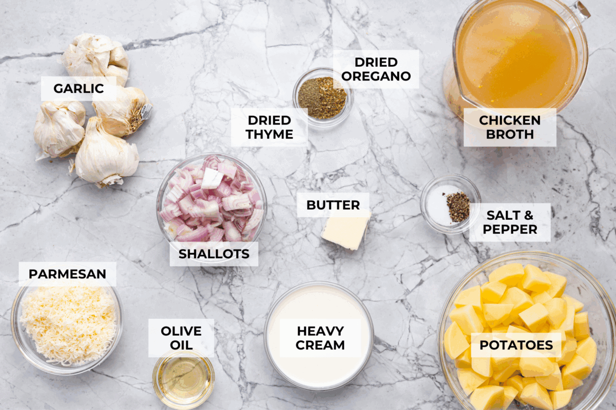 Creamy roasted garlic soup is comfort food with a side of obsession. Combining roasted garlic, tender potatoes, and nutty Parmesan into a cozy soup is absolute perfection. Just make sure you serve it to anyone within hugging distance. Overhead shot of labeled roasted garlic soup ingredients.