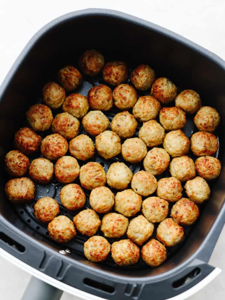 Air fryer frozen meatballs in the air fryer basket.