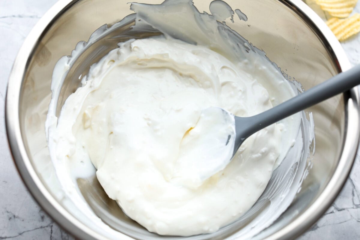 Sour cream and cream cheese mixed together in a mixing bowl.