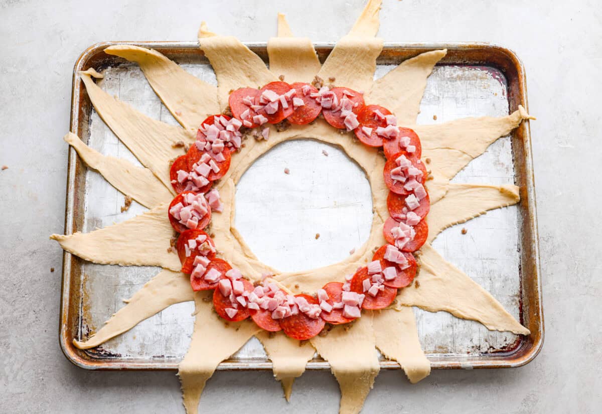 sauce and toppings in a ring on the sunburst crescent dough shape. 