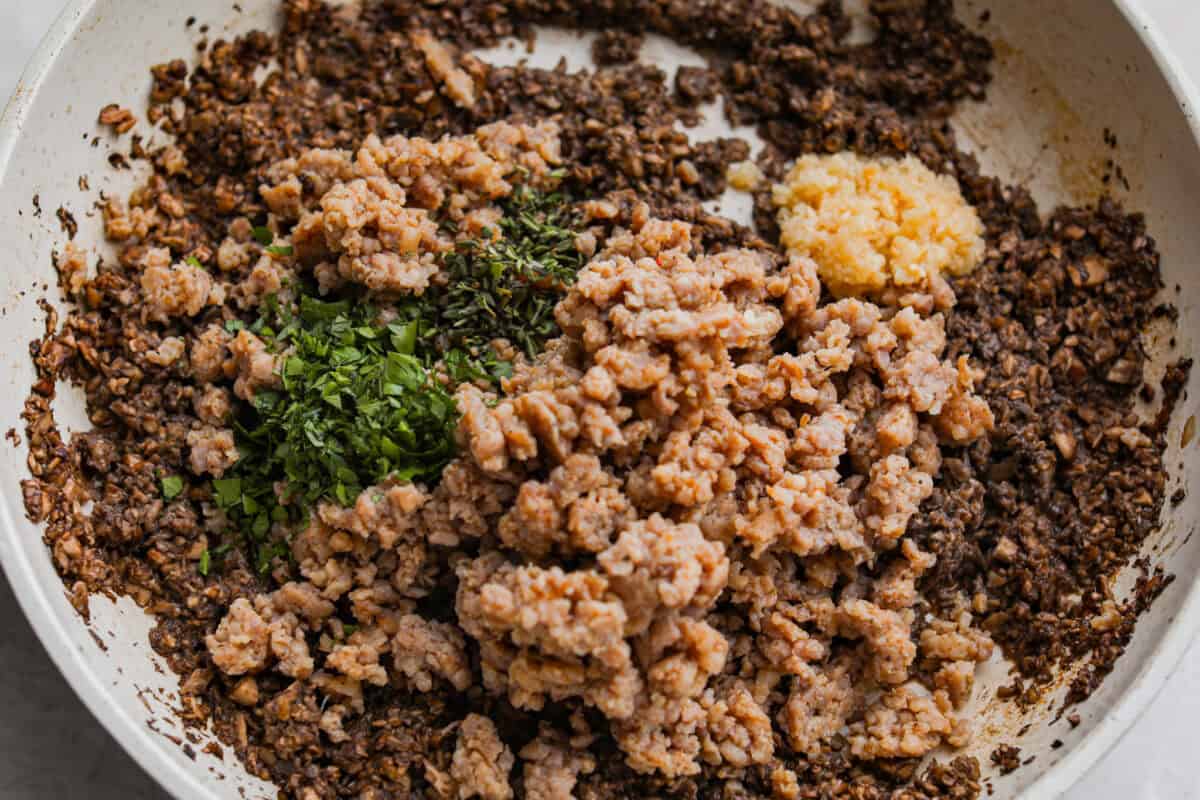 Sausage and seasonings added to the cooked mushrooms. 