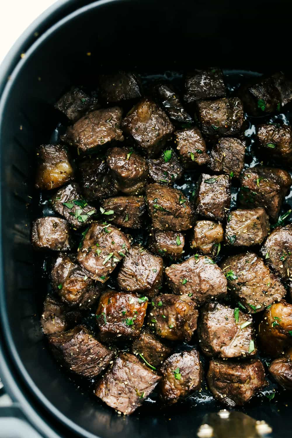 A close up of garlic steak bites in the air fryer. 
