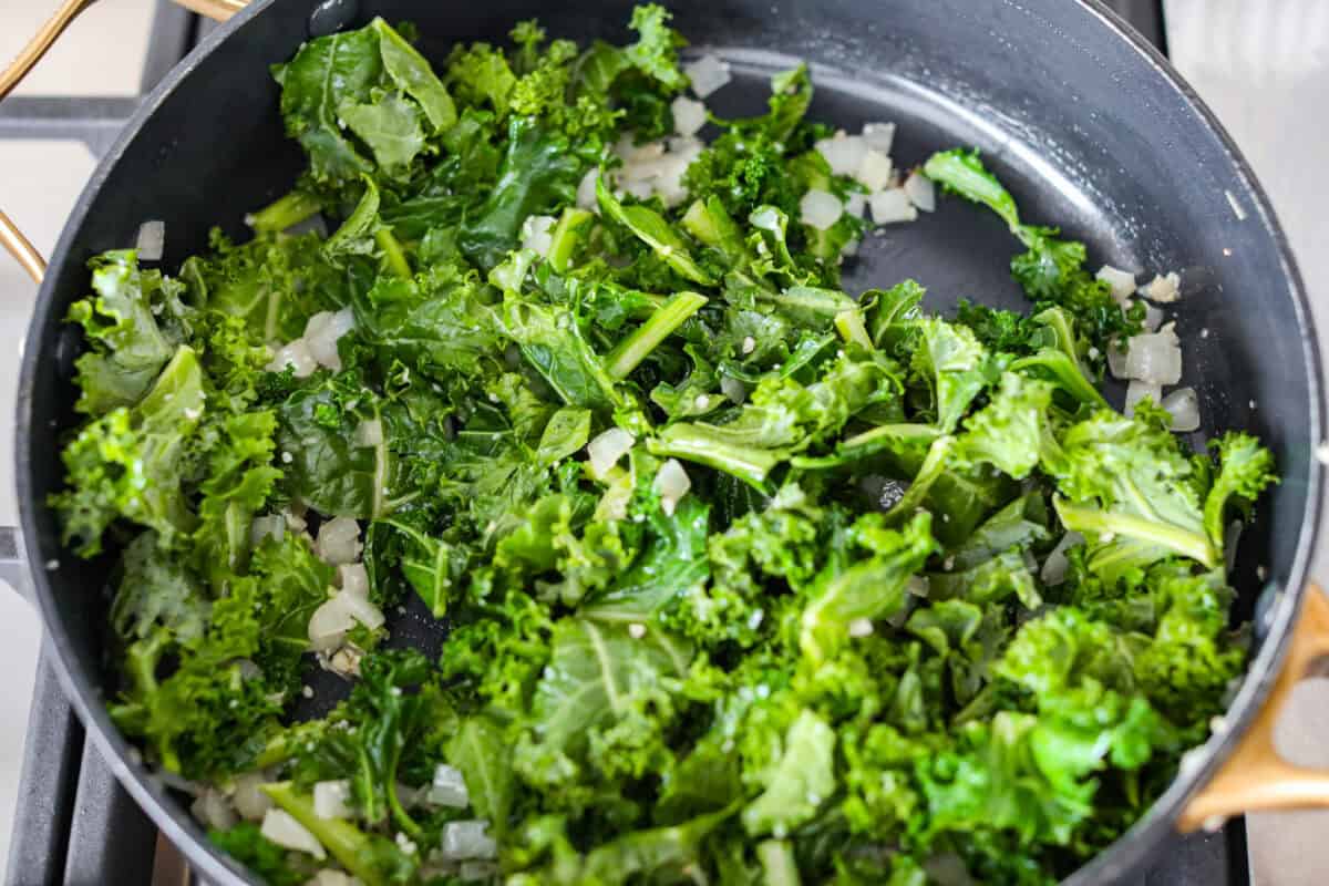 Kale added to the onion and garlic.