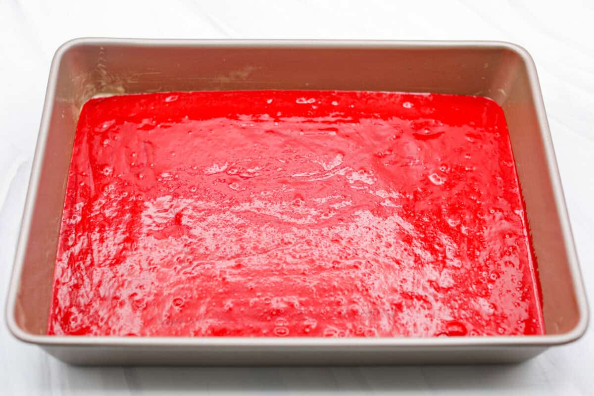 This 2-ingredient red velvet cake is almost too easy to believe! With just a cake mix and a can of soda, you can make a soft, fluffy cake in minutes. It’s the perfect shortcut dessert for Valentine’s Day or any sweet craving! Cake batter poured into a cake pan ready to go into the oven.