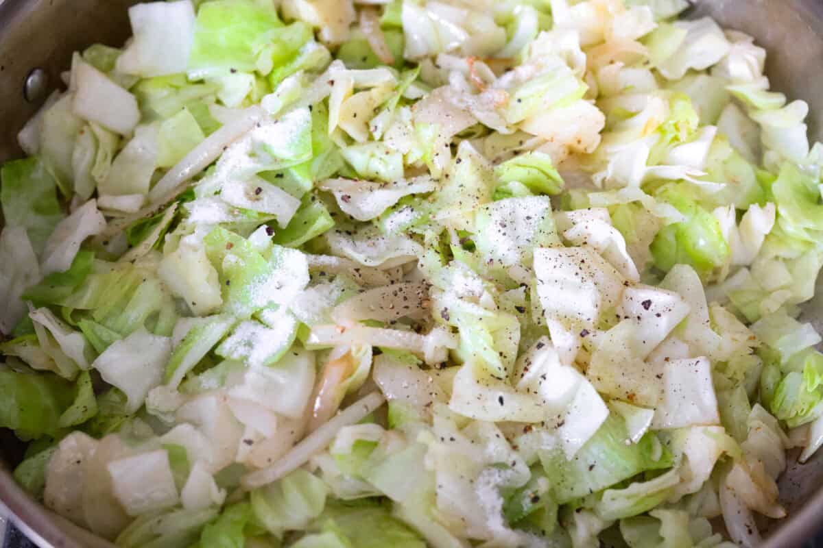 Seasonings added to the cabbage cooking in a skillet. 