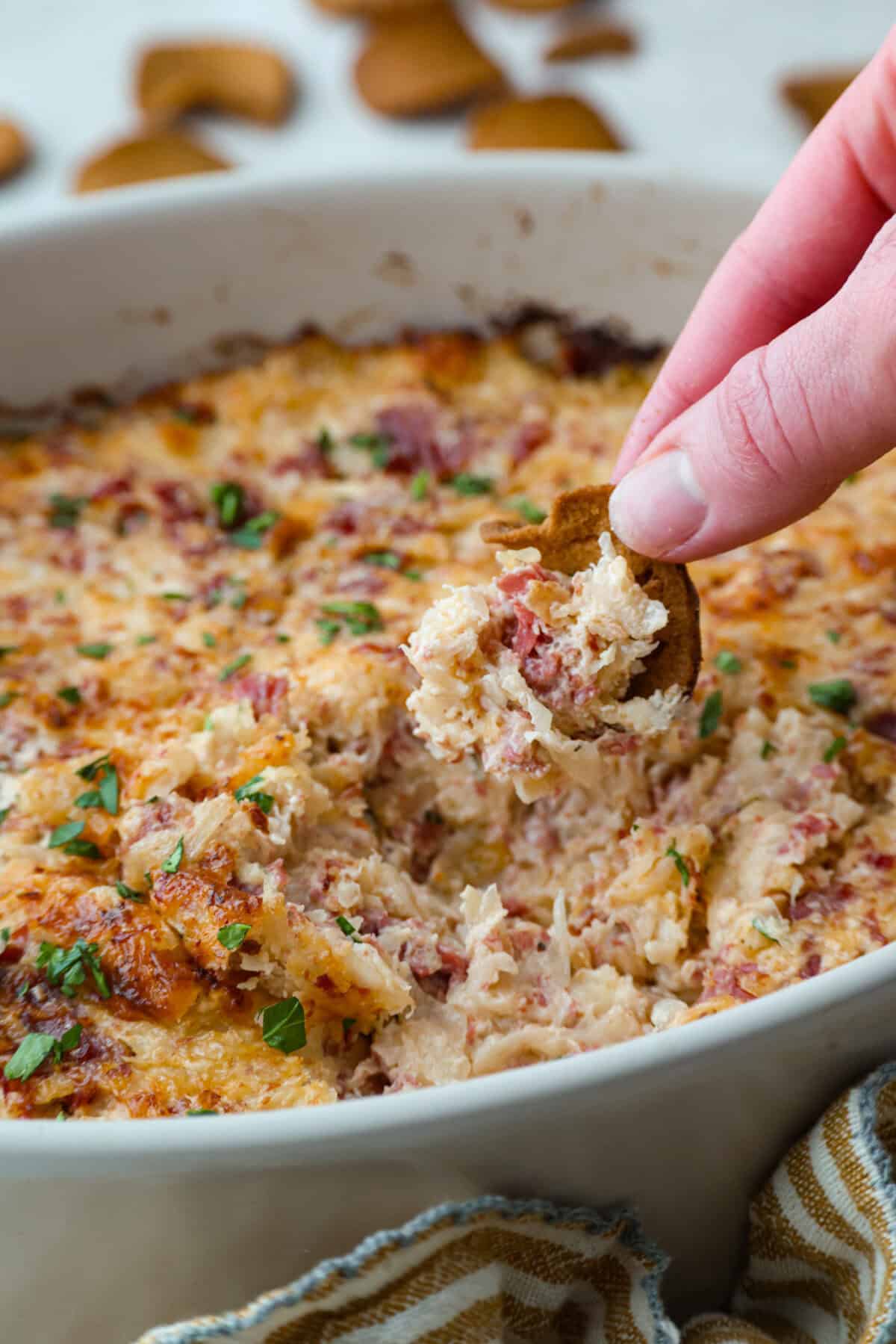 Think of this hot Reuben dip as a love letter to the classic Reuben sandwich. It’s rich, tangy, loaded with corned beef and sauerkraut, and the perfect way to turn St. Patrick’s Day leftovers into something everyone fights over. Someone scooping a bite of hot Reuben dip.