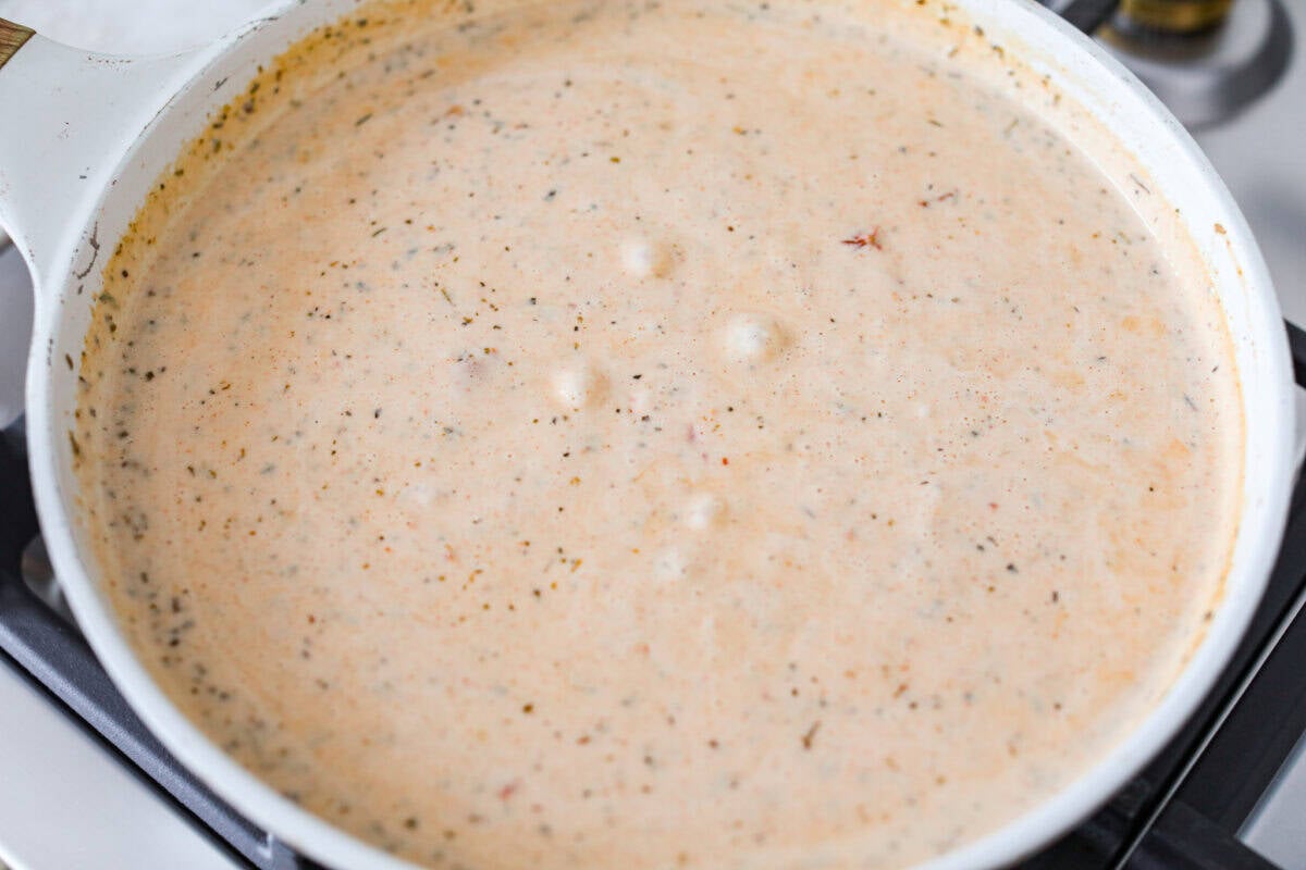 Sun-dried tomatoes and seasonings added to the skillet.