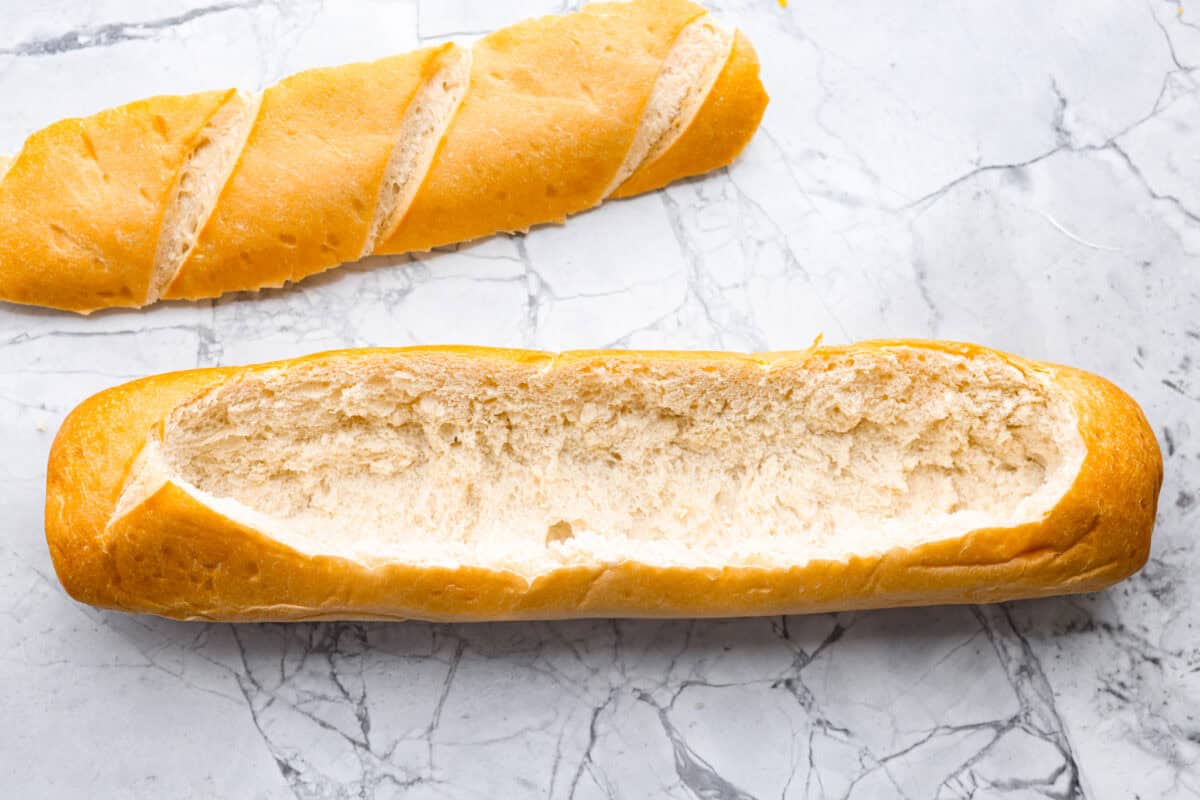 This Mississippi sin dip is pure comfort-food goodness. Creamy, cheesy, a little smoky, and baked into a loaf of French bread, it’s the kind of snack everyone gathers around and keeps going back for! Loaf of french bread cut in half the long way and the bread pulled out of the middle.