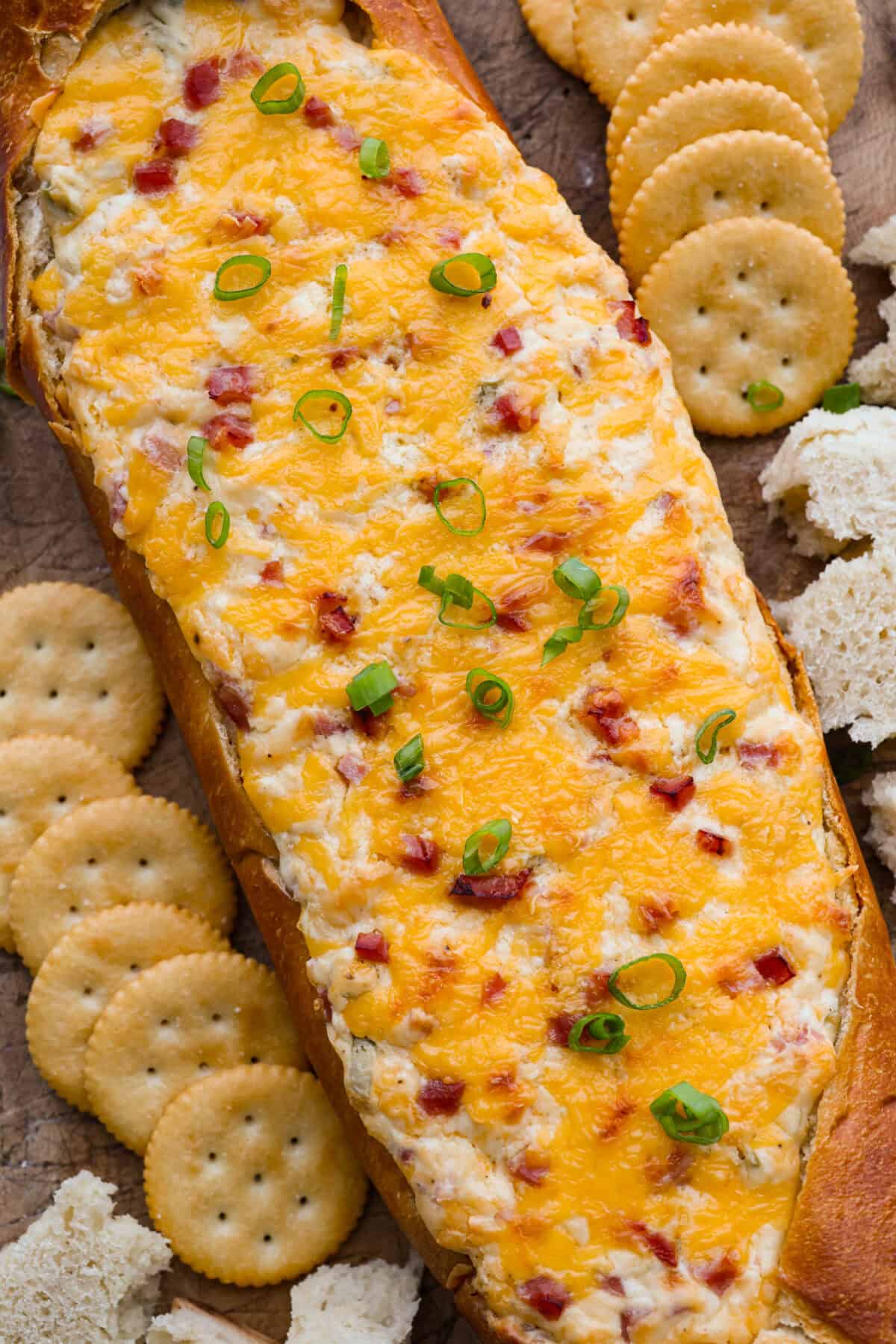 This Mississippi sin dip is pure comfort-food goodness. Creamy, cheesy, a little smoky, and baked into a loaf of French bread, it’s the kind of snack everyone gathers around and keeps going back for! Overhead shot of Mississippi sin dip surrounded by crackers.