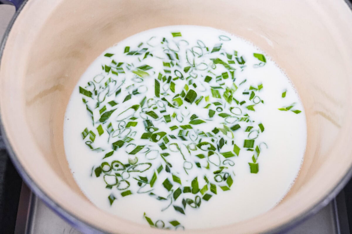 Irish champ potatoes are mashed potatoes done right. Fluffy spuds meet warm onion kissed milk and a generous melt of Irish butter for a side that’s simple, rustic, and seriously so good! Green onions soaking in warm milk.