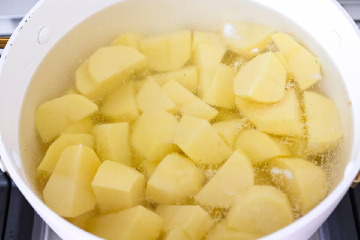 Irish champ potatoes are mashed potatoes done right. Fluffy spuds meet warm onion kissed milk and a generous melt of Irish butter for a side that’s simple, rustic, and seriously so good! Potatoes peeled and cut up and ready to cook in boiling water.