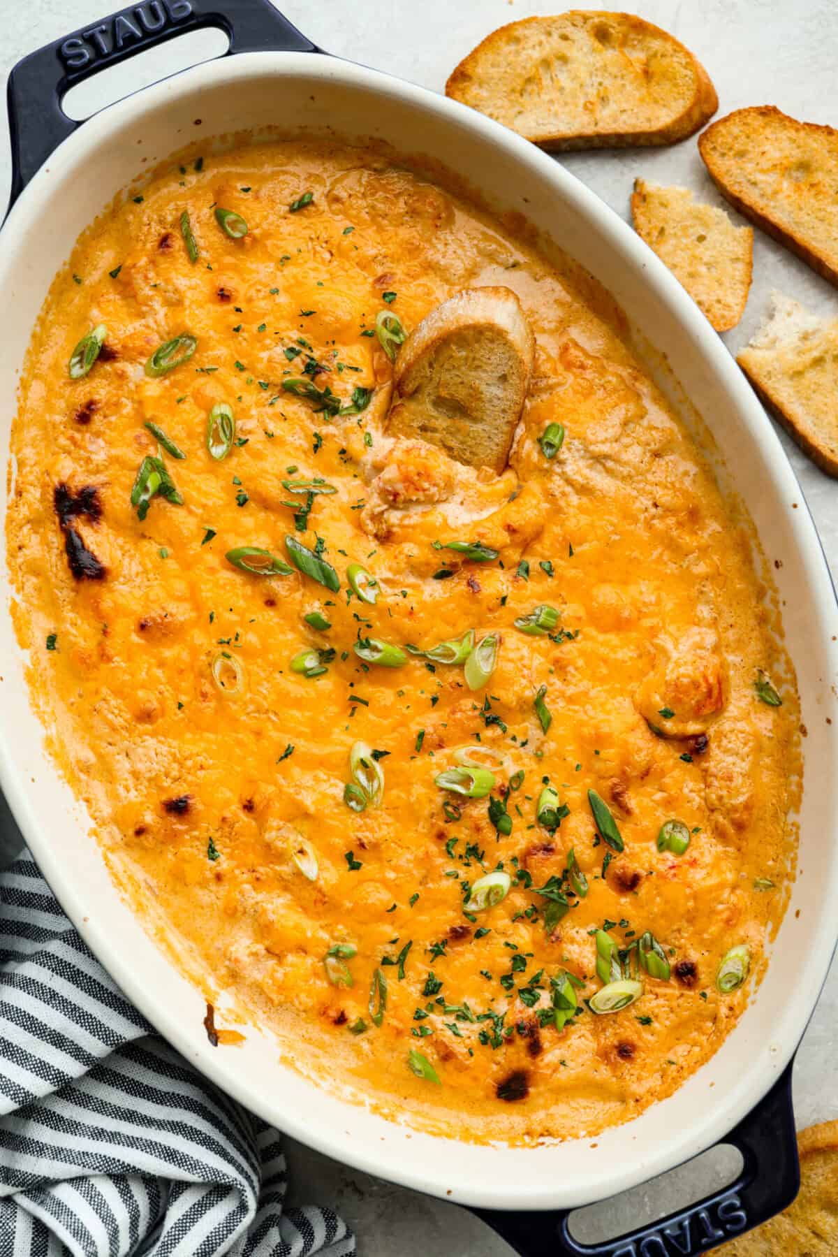 If you love a good lobster rolls, you’ll love it even more as a dip. Creamy, cheesy, and loaded with tender lobster, serve it warm, grab some crackers or bread, and let the dipping begin! Top down shot of the lobster roll dip all baked, and cheesy and perfect!
