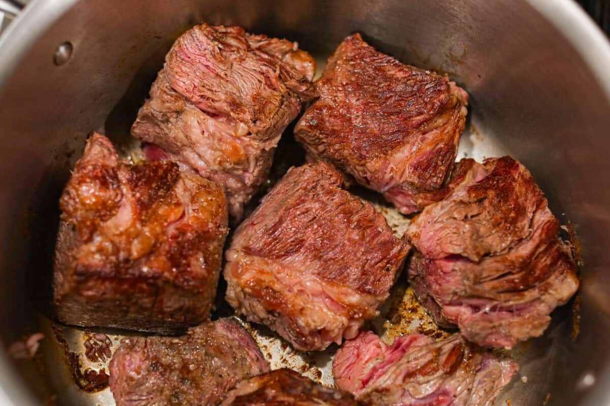 Meet Stracotto, the Italian pot roast you didn't know you were missing! A seared roast is slowly braised in a rich, hearty tomato sauce until it is melt-in-your-mouth tender. The sauce alone is worth making this recipe for! Beef browning in a pot.