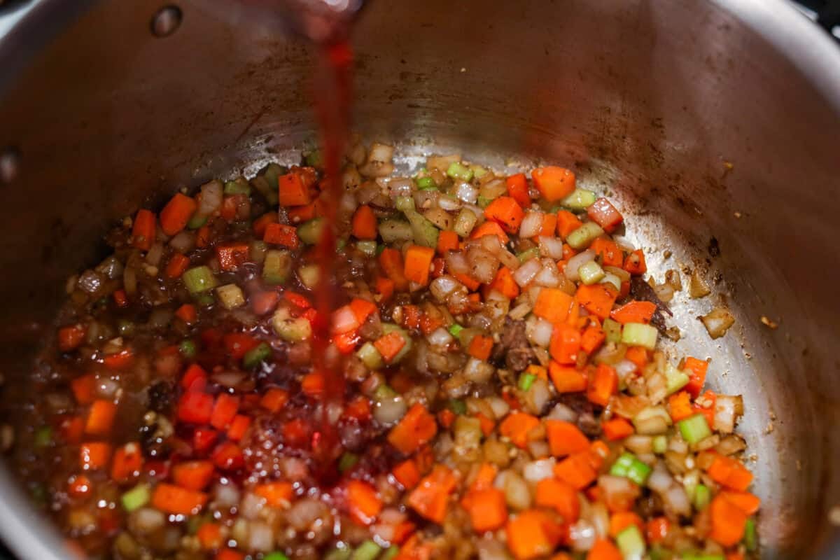 Meet Stracotto, the Italian pot roast you didn't know you were missing! A seared roast is slowly braised in a rich, hearty tomato sauce until it is melt-in-your-mouth tender. The sauce alone is worth making this recipe for! Wine being added to the veggies.