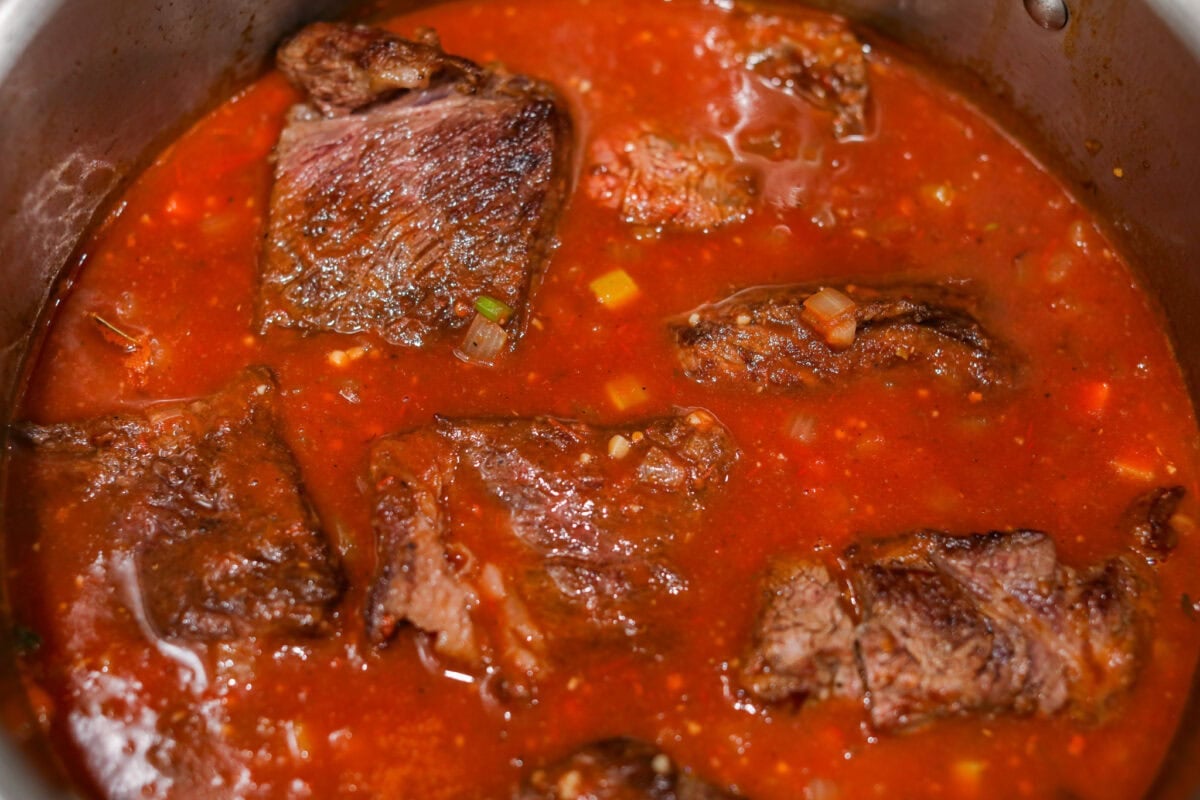 Meet Stracotto, the Italian pot roast you didn't know you were missing! A seared roast is slowly braised in a rich, hearty tomato sauce until it is melt-in-your-mouth tender. The sauce alone is worth making this recipe for! Beef added to the pot and ready to go in the oven.