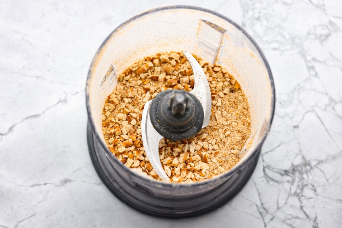 This pretzel crusted chicken takes crispy chicken to the next level. The crunchy pretzel coating adds incredible flavor and texture, making every bite extra delicious. Pretzels in a food processor being crushed for the outer coating.