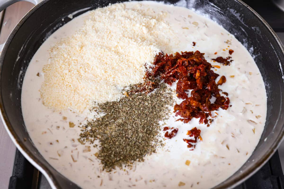 Groceries are expensive right now, so I’ve been leaning hard on the cheap staples. This melting cabbage with a garlicky cream sauce, sun-dried tomatoes, and Parmesan is easy, budget friendly, and tastes amazing. Parmesan, sun dried tomatoes, and seasonings added to the skillet.