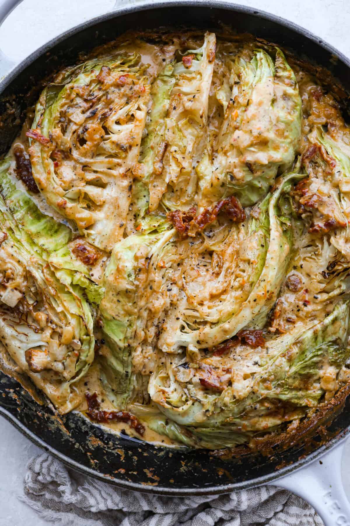 Groceries are expensive right now, so I’ve been leaning hard on the cheap staples. This melting cabbage with a garlicky cream sauce, sun-dried tomatoes, and Parmesan is easy, budget friendly, and tastes amazing. Skillet with creamy tuscan melting cabbage all cooked and ready to eat.