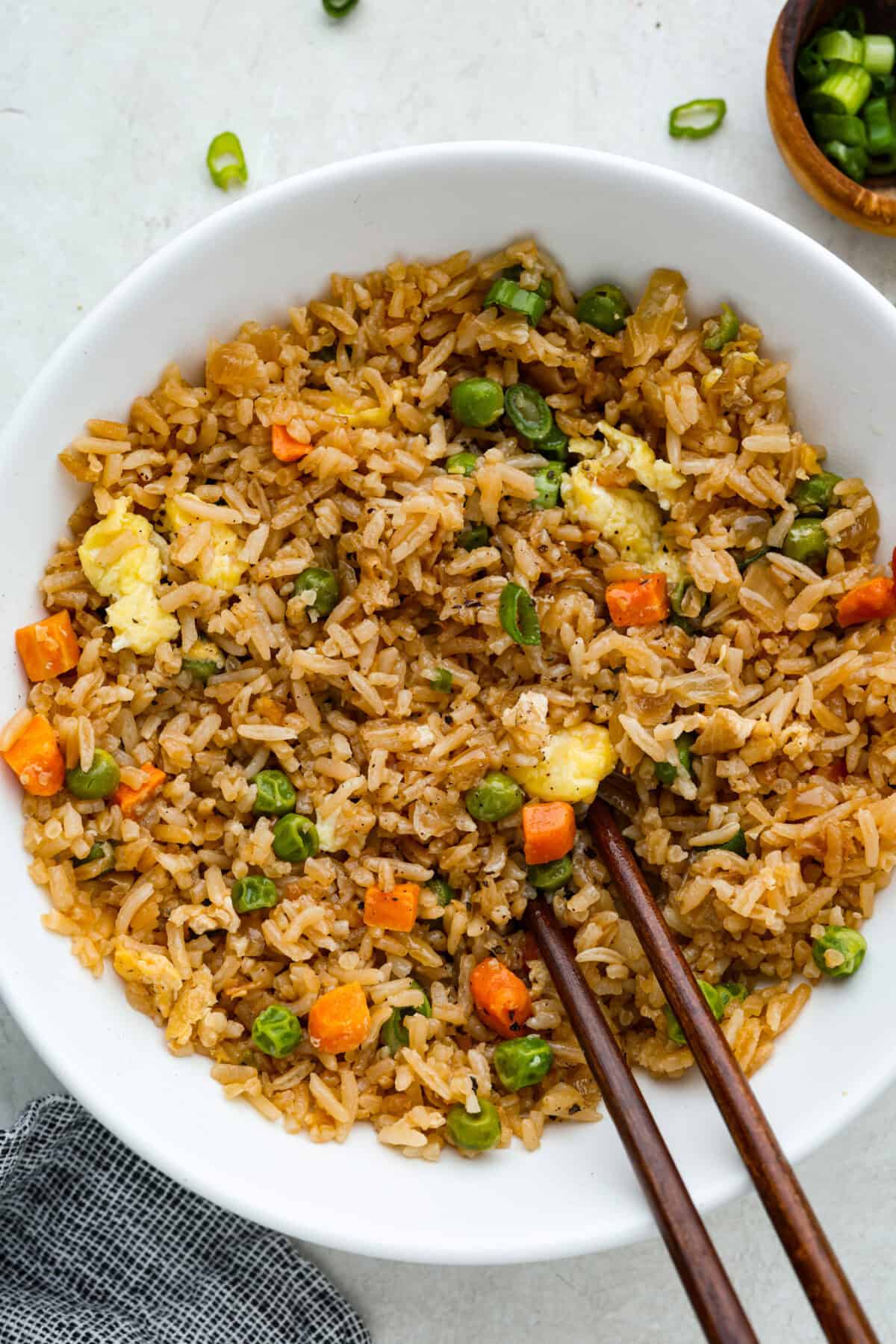 This is your one-stop spot for all my favorite fried rice recipes! Fried rice is one of those recipes that always saves dinner, especially when you have leftover chicken, extra ham, or cold rice sitting in the fridge. No matter what leftovers you have to work with, you'll find a fried rice recipe that will turn them into something delicious. Bowl of easy fried rice with chopsticks.