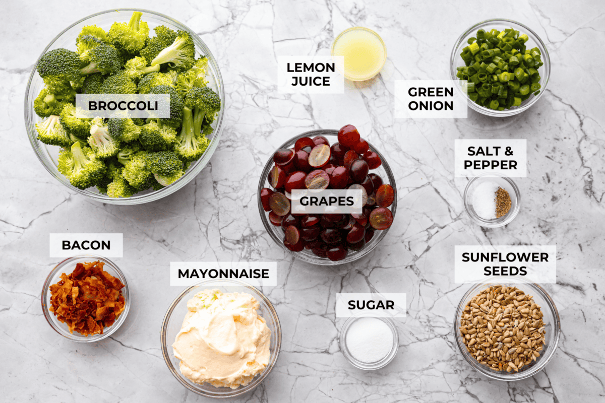 Broccoli grape salad is the crunchy, juicy, smoky combo nobody expects but everyone loves. Sweet grapes, crisp broccoli, smoky bacon, and a tangy lemon dressing come together in just 20 minutes! Overhead shot of labeled broccoli grape salad ingredients.