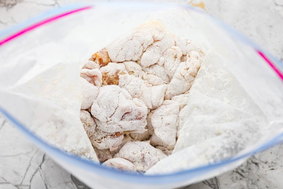 Chicken pieces in a bag with cornstarch and flour. 