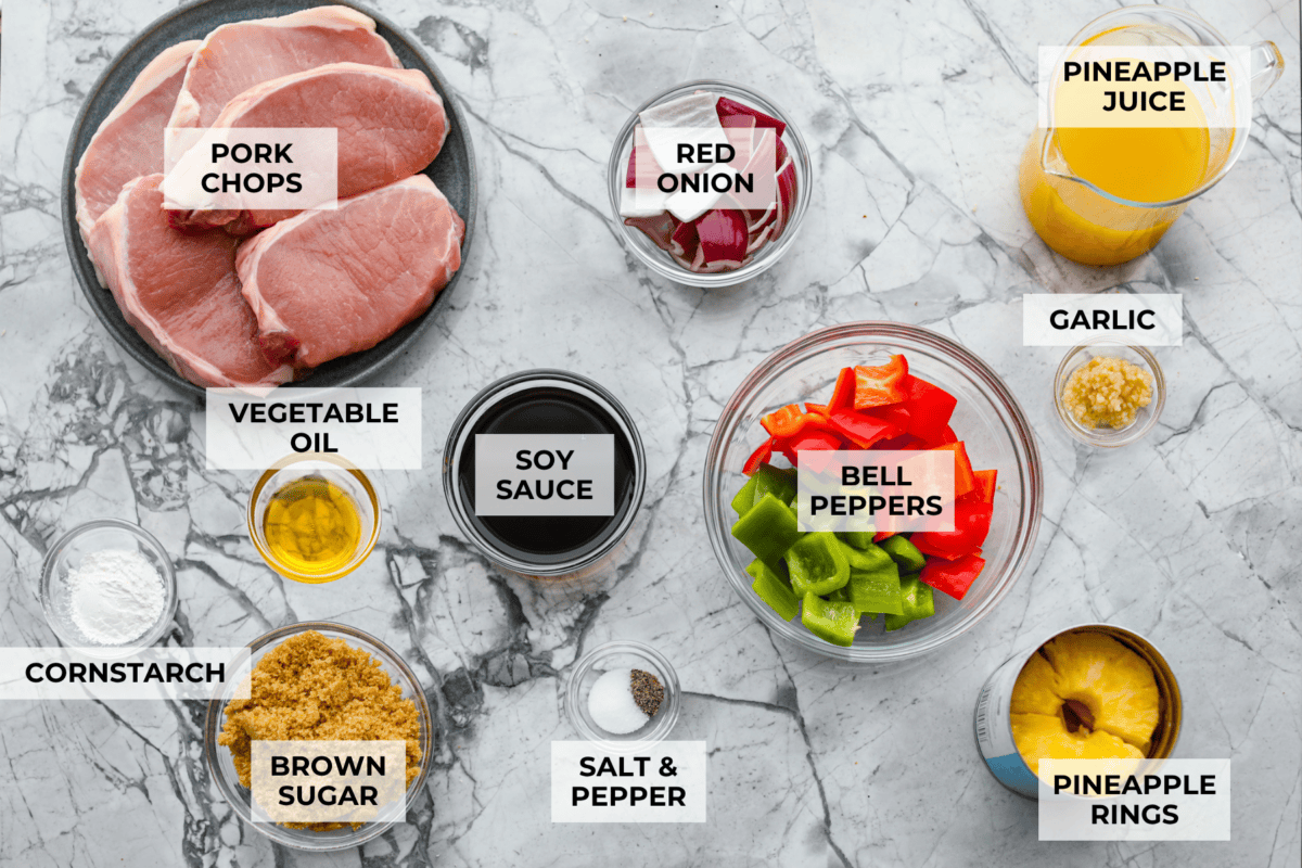 My Hawaiian pork chops are sweet, savory, colorful, and so easy! Pork chops simmer in a pineapple sauce with bell peppers, making the whole skillet irresistible. Serve it over rice so you can catch every drop of that delicious sauce. Overhead shot of labeled ingredients.