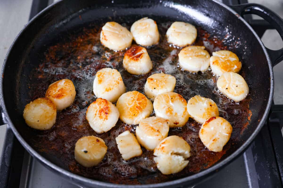 My pan seared scallops recipe has been a reader favorite for years, and one bite will show you why. The buttery golden scallops with that bright, fresh lemon flavor are what make this recipe stand out from all the others. Scallops in a pan searing.