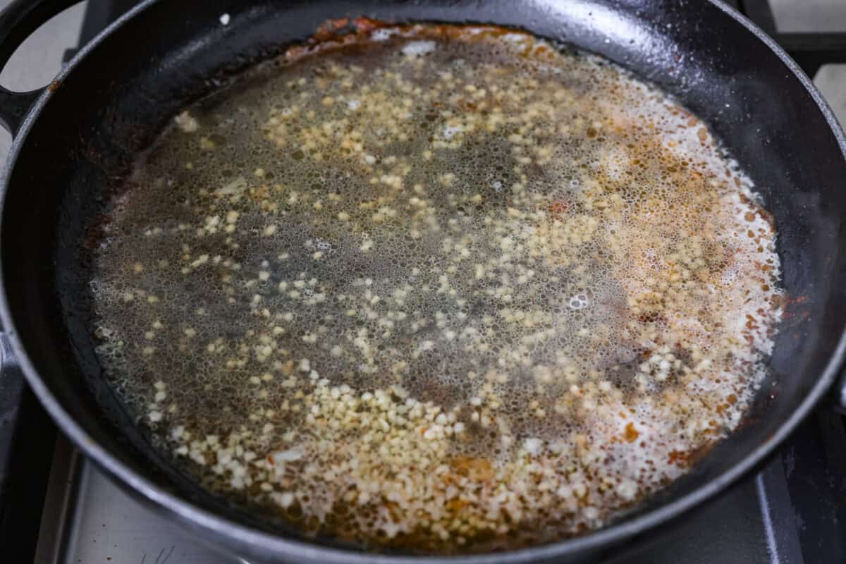 My pan seared scallops recipe has been a reader favorite for years, and one bite will show you why. The buttery golden scallops with that bright, fresh lemon flavor are what make this recipe stand out from all the others. Garlic and white wine simmering in a pan.