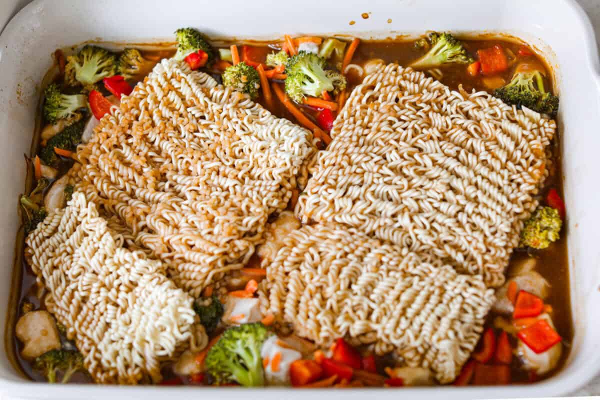 I kept seeing this dump and bake ramen all over my feed and finally had to try it for myself! Turning family favorite ramen into a cozy baked dinner was an immediate hit! It's so good with tender noodles, colorful veggies, and a savory sauce! Sauce dumped over the veggies and noodles.